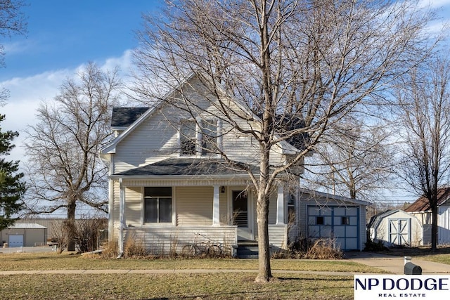 1042 Seward St, Seward, NE 68434 - view of front of home with a shed, covered porch, an outdoor structure, concrete driveway, and roof with shingles