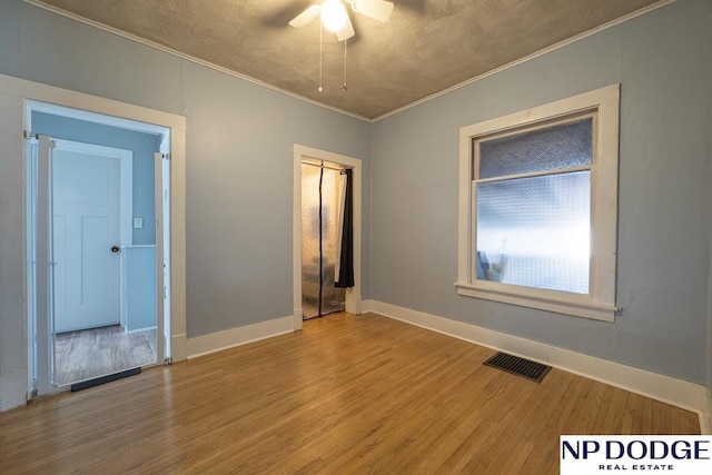 1042 Seward St, Seward, NE 68434 - empty room featuring visible vents, crown molding, ceiling fan, and wood finished floors