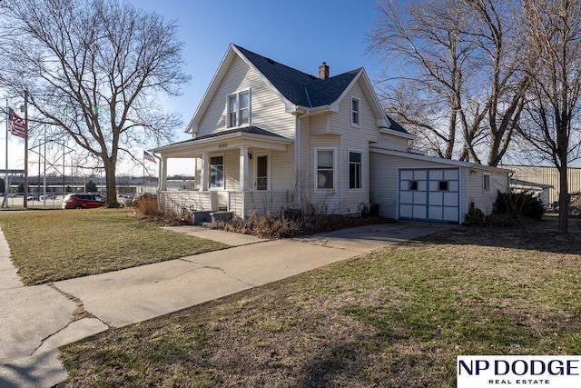 1042 Seward St, Seward, NE 68434 - view of front of property featuring a garage, a porch, concrete driveway, and a front lawn