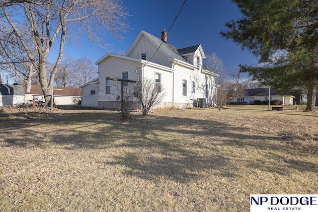 1042 Seward St, Seward, NE 68434 - view of home's exterior featuring a yard, central AC unit, and a chimney