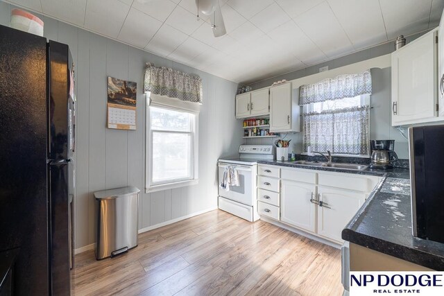 1042 Seward St, Seward, NE 68434 - kitchen featuring light wood-type flooring, freestanding refrigerator, white range with electric stovetop, white cabinets, and a sink