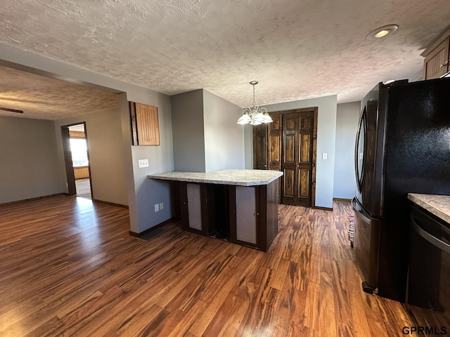 108 S Quince Ave, Dewitt, NE 68341 - kitchen with dark wood finished floors, a peninsula, freestanding refrigerator, a textured ceiling, and a chandelier