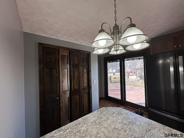 108 S Quince Ave, Dewitt, NE 68341 - unfurnished bedroom with a textured ceiling, freestanding refrigerator, an inviting chandelier, and access to outside