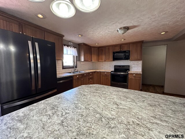 108 S Quince Ave, Dewitt, NE 68341 - kitchen featuring black appliances, light stone countertops, backsplash, and a sink