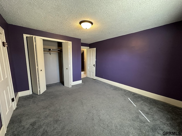 108 S Quince Ave, Dewitt, NE 68341 - unfurnished bedroom with a closet, a textured ceiling, baseboards, and dark colored carpet