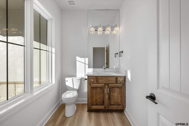 10907 N 167th St, Bennington, NE 68007 - bathroom featuring toilet, vanity, wood finished floors, and baseboards