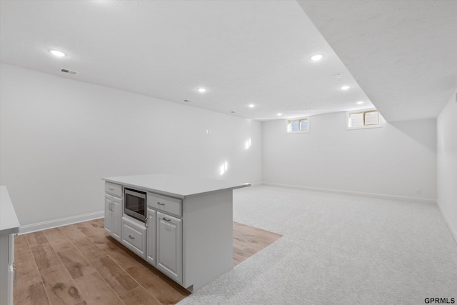 10907 N 167th St, Bennington, NE 68007 - kitchen featuring stainless steel microwave, recessed lighting, light countertops, a kitchen island, and baseboards