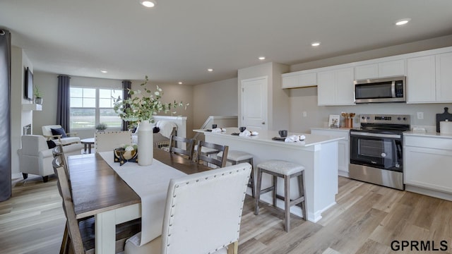 13607 Whitmore St, Omaha, NE 68142 - kitchen with appliances with stainless steel finishes, light wood-style flooring, white cabinets, recessed lighting, and light countertops