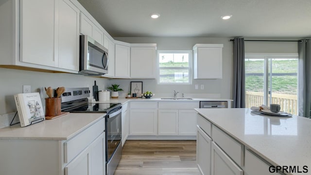 13607 Whitmore St, Omaha, NE 68142 - kitchen with appliances with stainless steel finishes, a sink, healthy amount of natural light, white cabinets, and recessed lighting