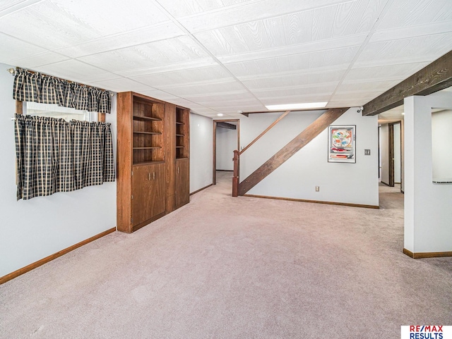 finished below grade area featuring stairs, carpet flooring, and baseboards