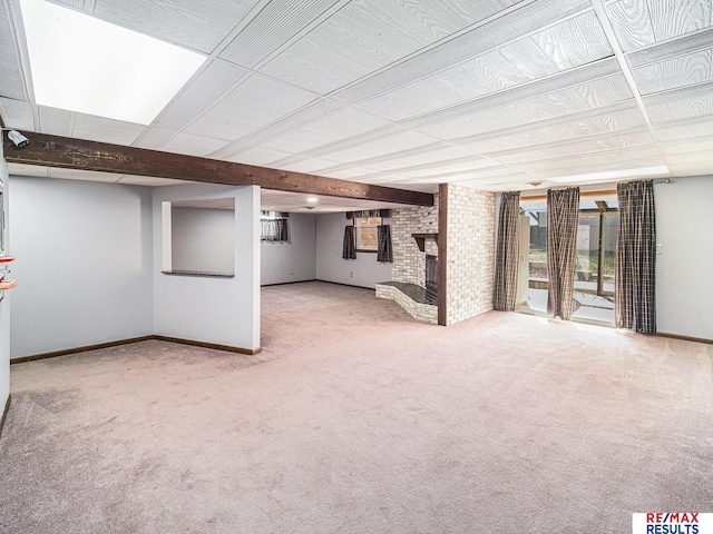 basement with plenty of natural light, carpet flooring, and a brick fireplace
