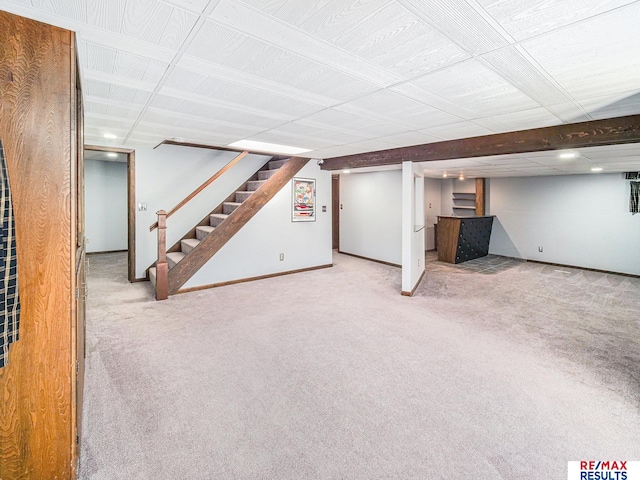 finished basement featuring carpet flooring, stairway, and baseboards