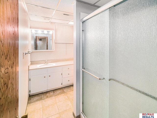 bathroom featuring visible vents, a paneled ceiling, a shower stall, vanity, and tile patterned floors