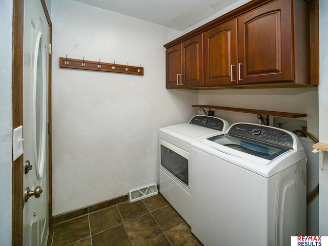 clothes washing area with cabinet space, visible vents, washer and clothes dryer, and dark tile patterned floors