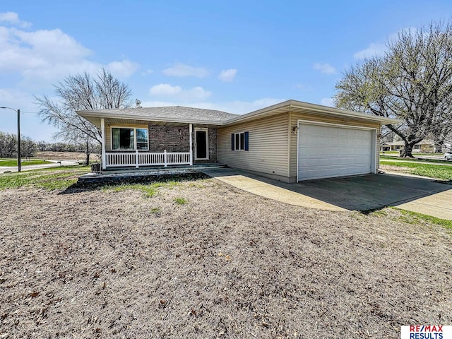 ranch-style house featuring covered porch, a garage, and concrete driveway