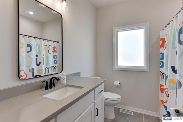 bathroom featuring vanity, toilet, baseboards, tile patterned floors, and visible vents
