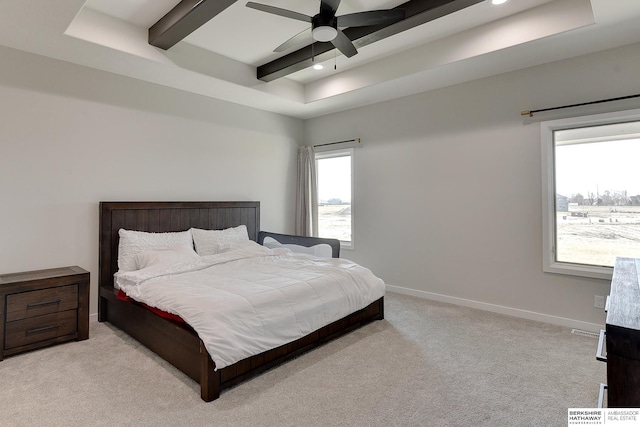 bedroom with a tray ceiling, light colored carpet, baseboards, beam ceiling, and a ceiling fan