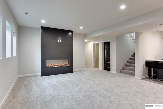 unfurnished living room featuring recessed lighting, carpet floors, visible vents, and stairway