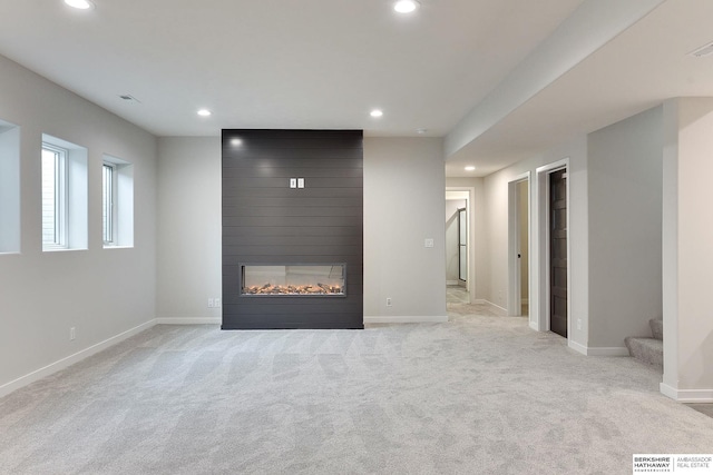 unfurnished living room featuring stairway, recessed lighting, baseboards, visible vents, and light carpet