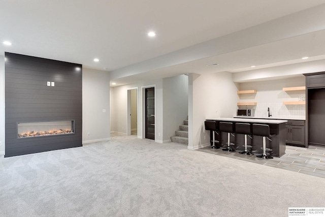 living area featuring stairs, indoor wet bar, light colored carpet, and recessed lighting