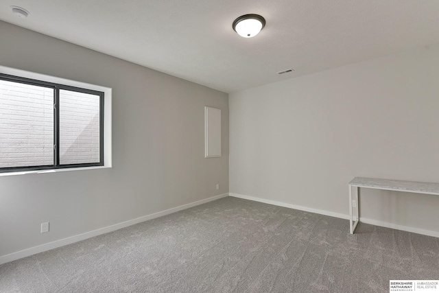 unfurnished room with baseboards, carpet flooring, and visible vents