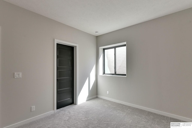 unfurnished bedroom featuring baseboards, carpet floors, a textured ceiling, and visible vents