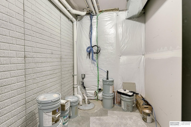 unfinished basement featuring brick wall
