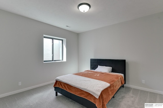 carpeted bedroom featuring baseboards and visible vents