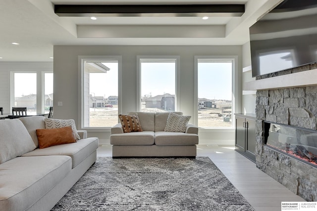 living area with beamed ceiling, baseboards, a fireplace, wood finished floors, and recessed lighting