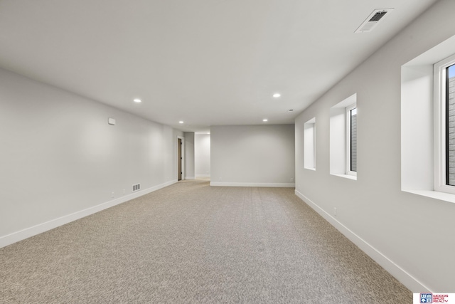unfurnished room featuring baseboards, visible vents, recessed lighting, and light colored carpet