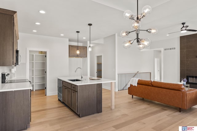 kitchen featuring a sink, open floor plan, stainless steel appliances, visible vents, and light wood-style floors