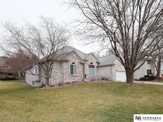 view of front of home with brick siding, a garage, driveway, and a front yard