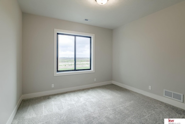 carpeted empty room featuring visible vents and baseboards
