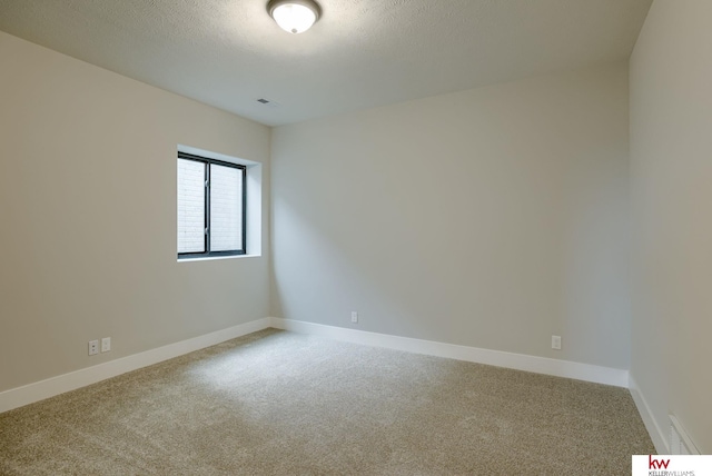 unfurnished room featuring carpet floors, a textured ceiling, and baseboards