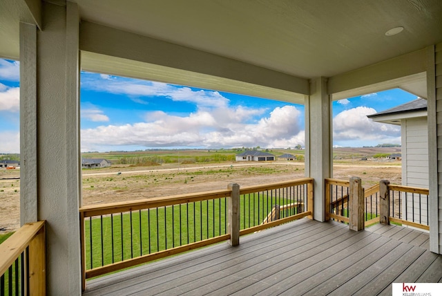 wooden deck featuring a yard and a rural view