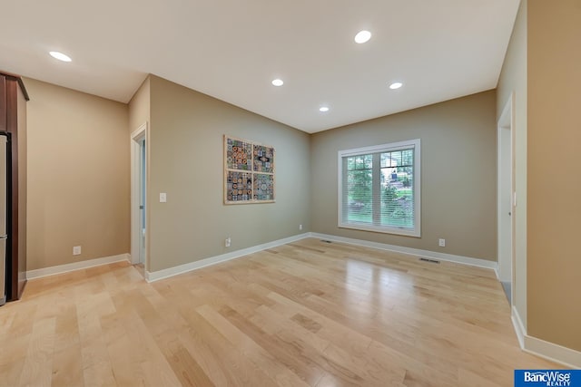 empty room featuring baseboards, visible vents, recessed lighting, and light wood-style floors