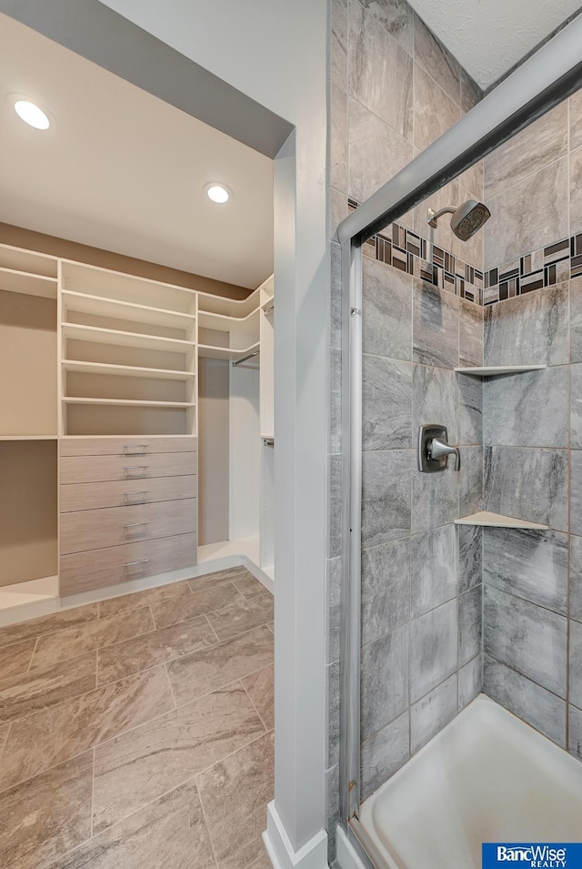 full bath with recessed lighting, a walk in closet, and a shower stall