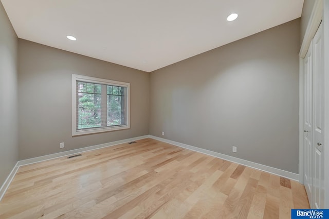 unfurnished room featuring baseboards, visible vents, light wood-style flooring, and recessed lighting