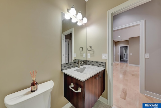 bathroom with baseboards, vanity, and tasteful backsplash