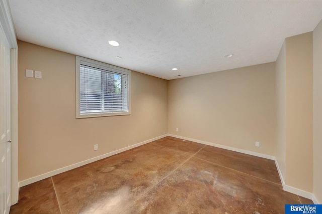 unfurnished room with baseboards, recessed lighting, concrete flooring, and a textured ceiling
