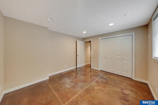 unfurnished bedroom with baseboards, concrete floors, a closet, and recessed lighting
