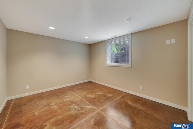empty room with baseboards, recessed lighting, and concrete flooring