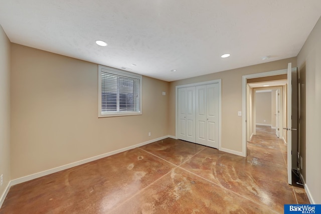 unfurnished bedroom with recessed lighting, concrete floors, baseboards, a textured ceiling, and a closet