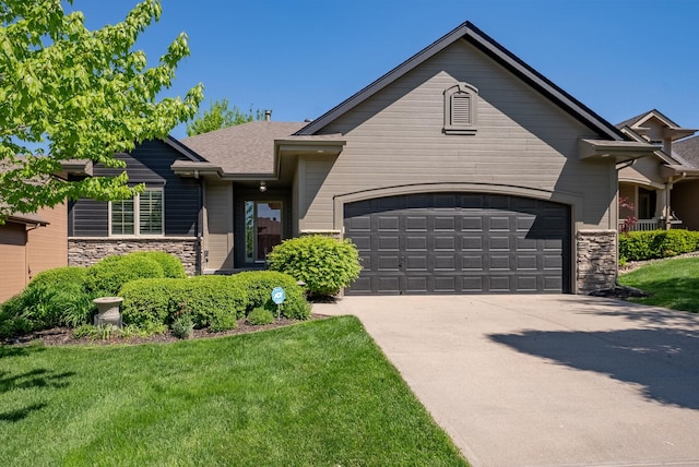 view of front of property featuring stone siding, an attached garage, concrete driveway, and a front yard