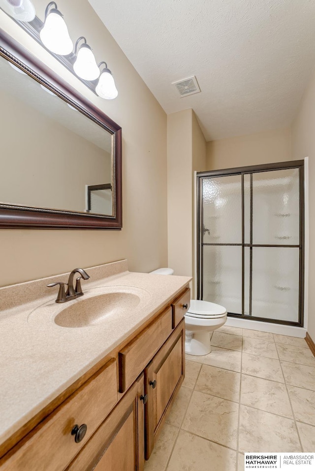 bathroom featuring a shower stall, toilet, and vanity
