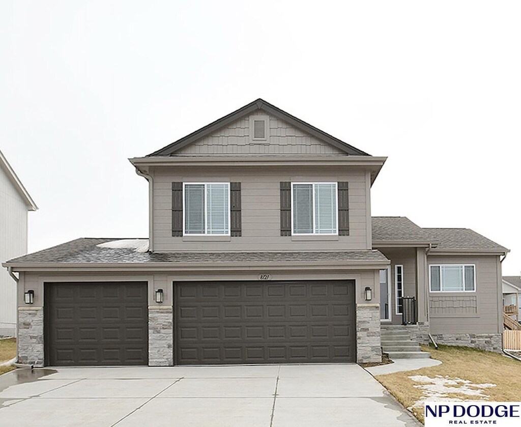 view of front facade with driveway, an attached garage, and stone siding