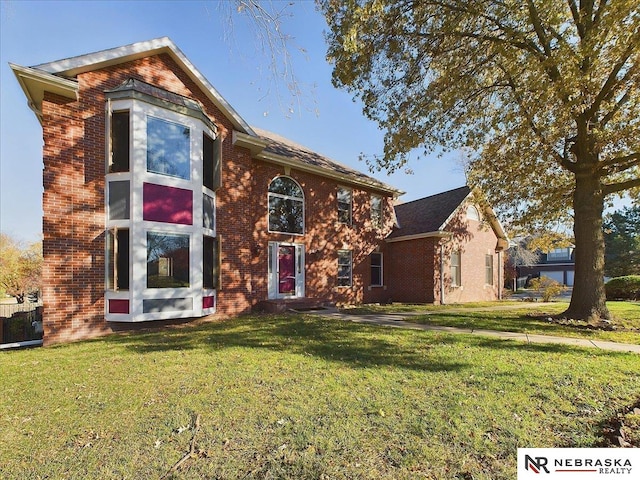 traditional home featuring a front lawn, central AC unit, and brick siding