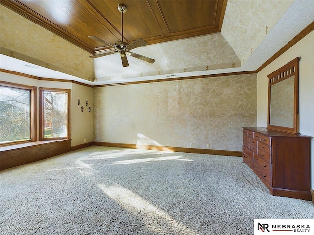 empty room featuring a tray ceiling, crown molding, light carpet, and a ceiling fan