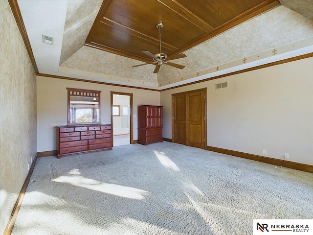 unfurnished bedroom featuring baseboards, a tray ceiling, visible vents, and ornamental molding