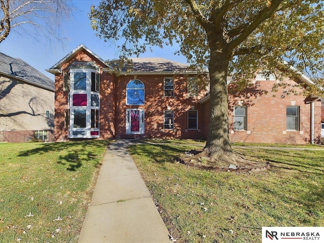 view of front of home with brick siding and a front lawn